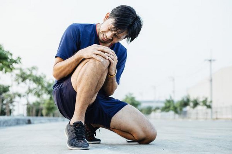 Person holding their knee in pain - Intervene Herbal Pain Relief aims to alleviate joint pain and improve quality of life.